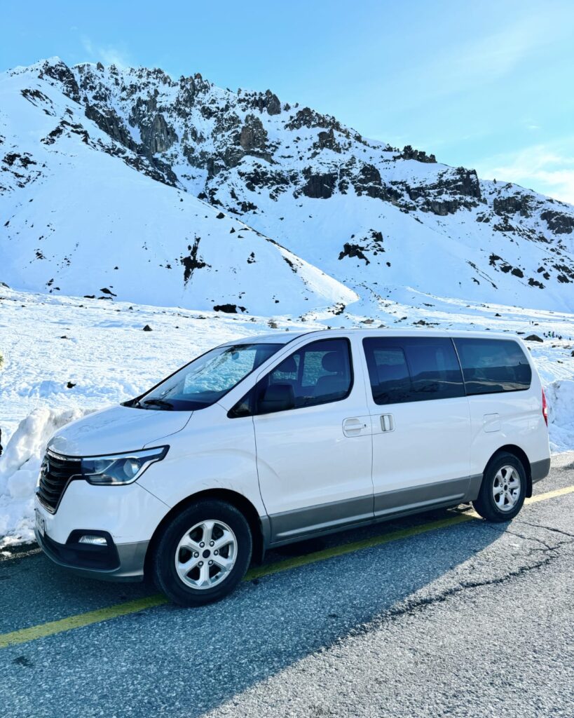 Van blanca en la nieve, traslado a Farellones y centros de ski con Transportes DAEX